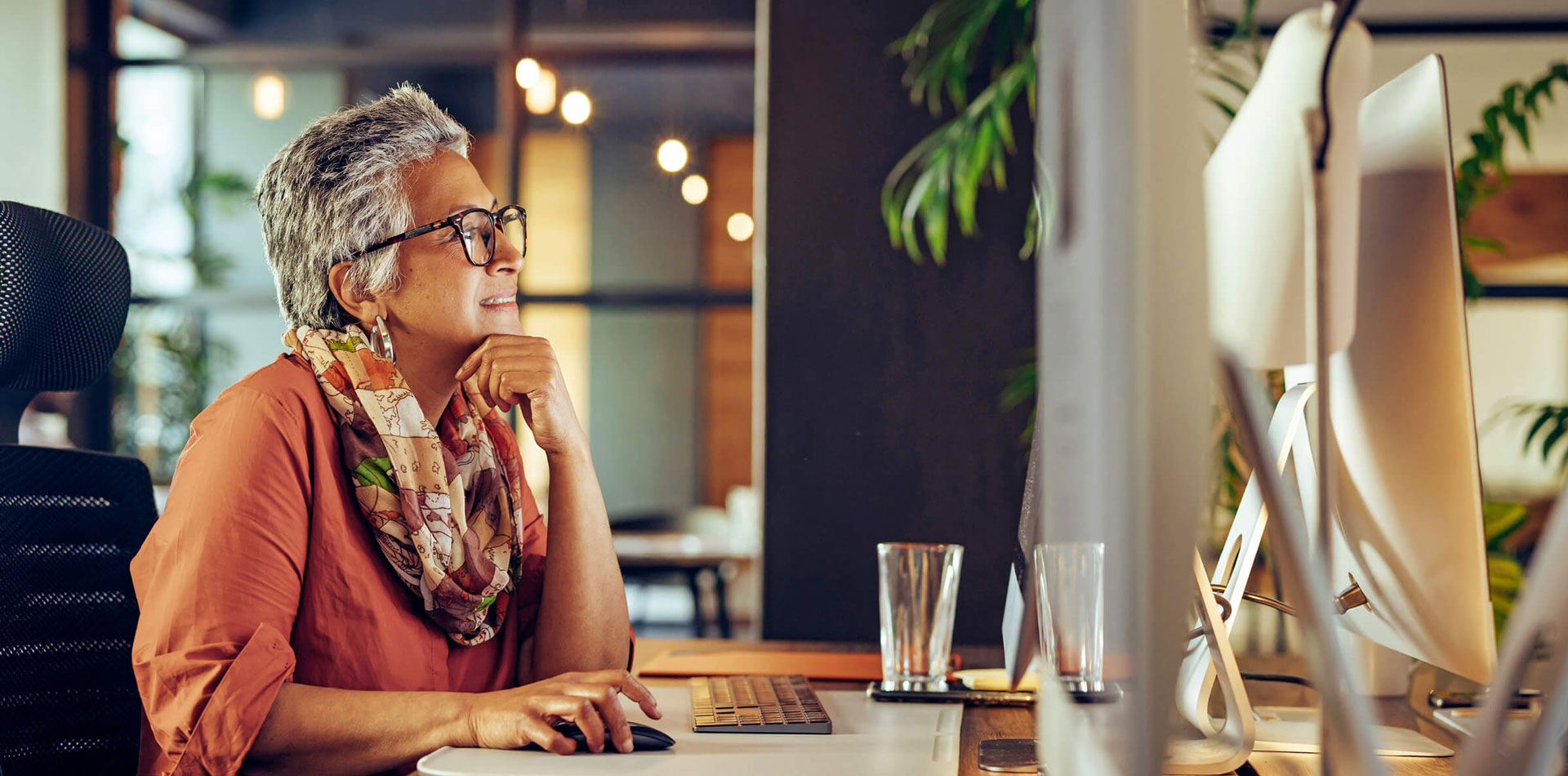Woman in glasses with computer at desk